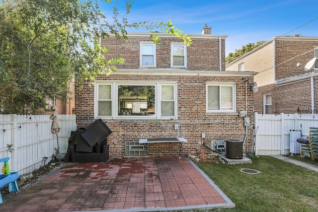 rear view of house with a yard, a patio, and central air condition unit