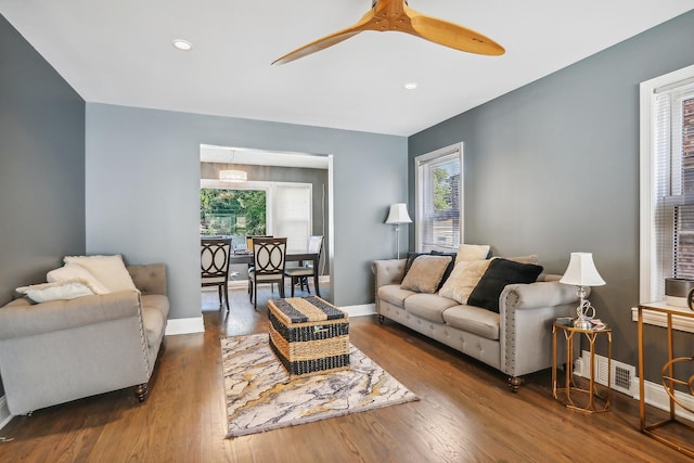 living room featuring ceiling fan and dark wood-type flooring