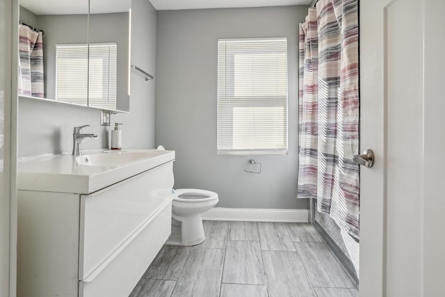 bathroom featuring wood-type flooring, vanity, and toilet