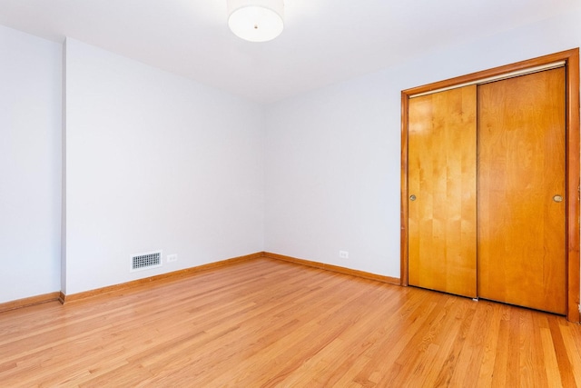 unfurnished bedroom with a closet and light wood-type flooring