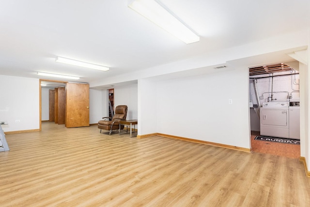 basement featuring light wood-type flooring and separate washer and dryer