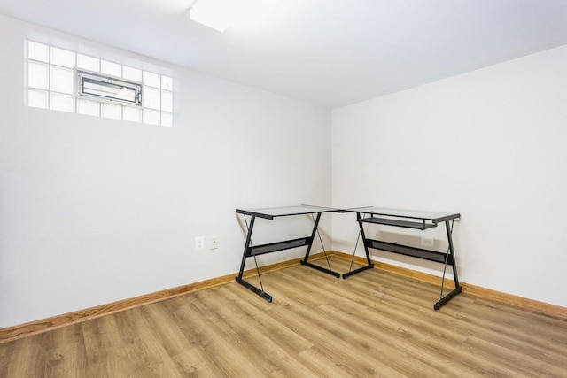 basement with light hardwood / wood-style flooring