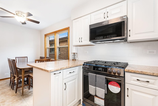 kitchen featuring backsplash, kitchen peninsula, white cabinetry, and stainless steel appliances