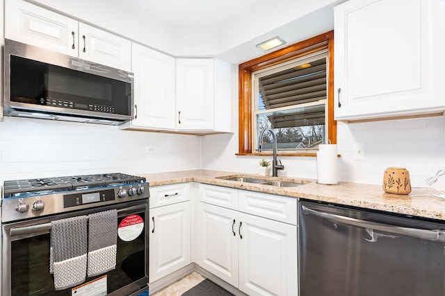 kitchen featuring backsplash, sink, white cabinetry, and stainless steel appliances