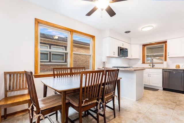 tiled dining area with ceiling fan and sink