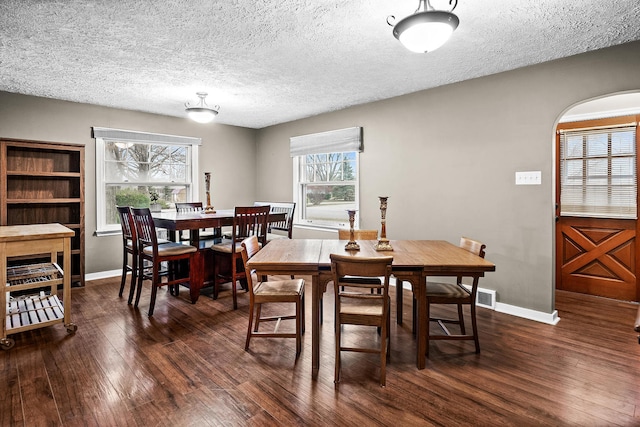 dining room with dark hardwood / wood-style flooring and a textured ceiling