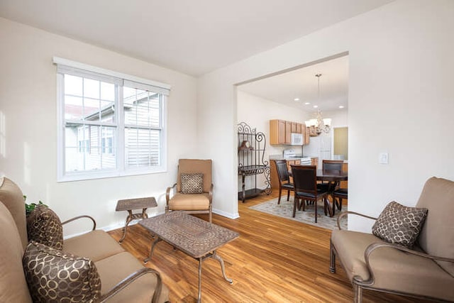 living room with light hardwood / wood-style floors and a notable chandelier