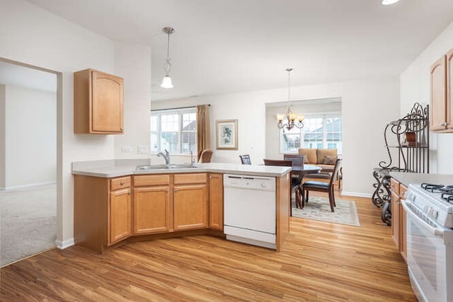 kitchen with pendant lighting, white appliances, light hardwood / wood-style floors, sink, and a chandelier