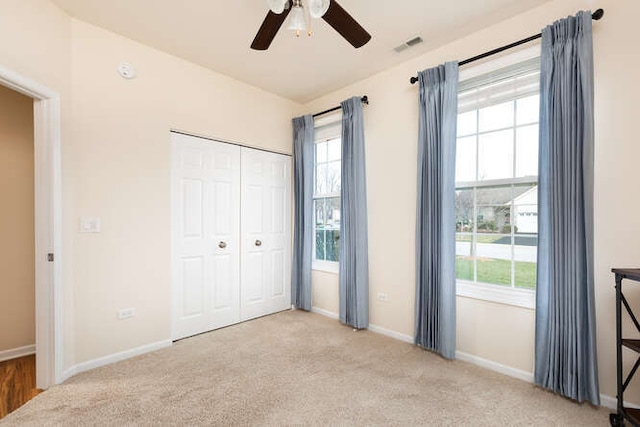 unfurnished bedroom featuring a closet, ceiling fan, and light carpet