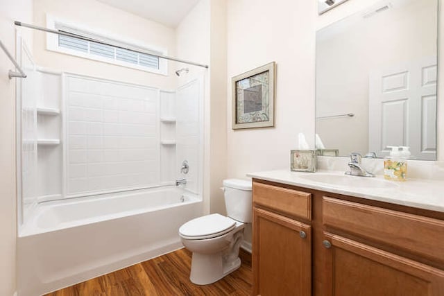 full bathroom featuring hardwood / wood-style flooring, washtub / shower combination, vanity, and toilet