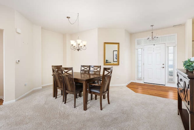 carpeted dining room with a notable chandelier