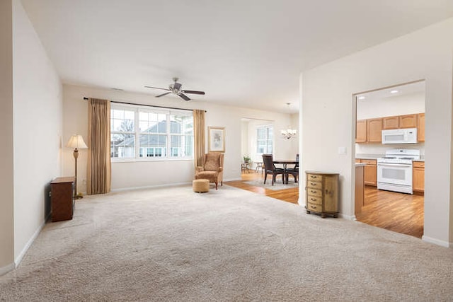 unfurnished room with ceiling fan with notable chandelier and light carpet