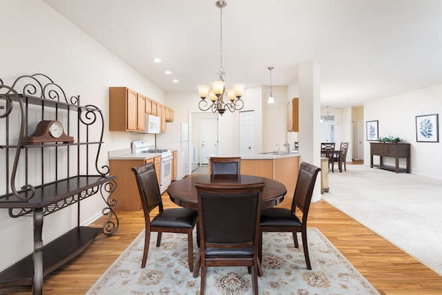 dining space with a chandelier and light wood-type flooring