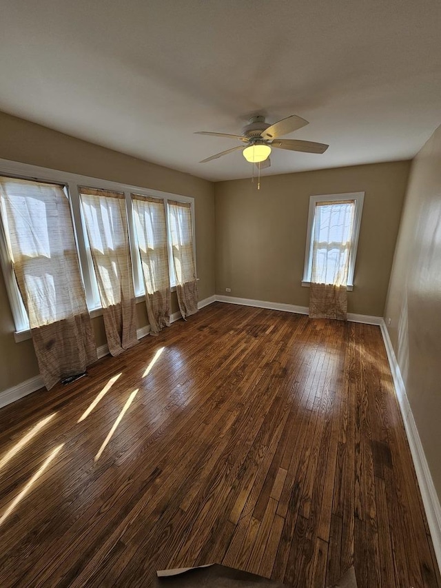 spare room with ceiling fan and dark wood-type flooring