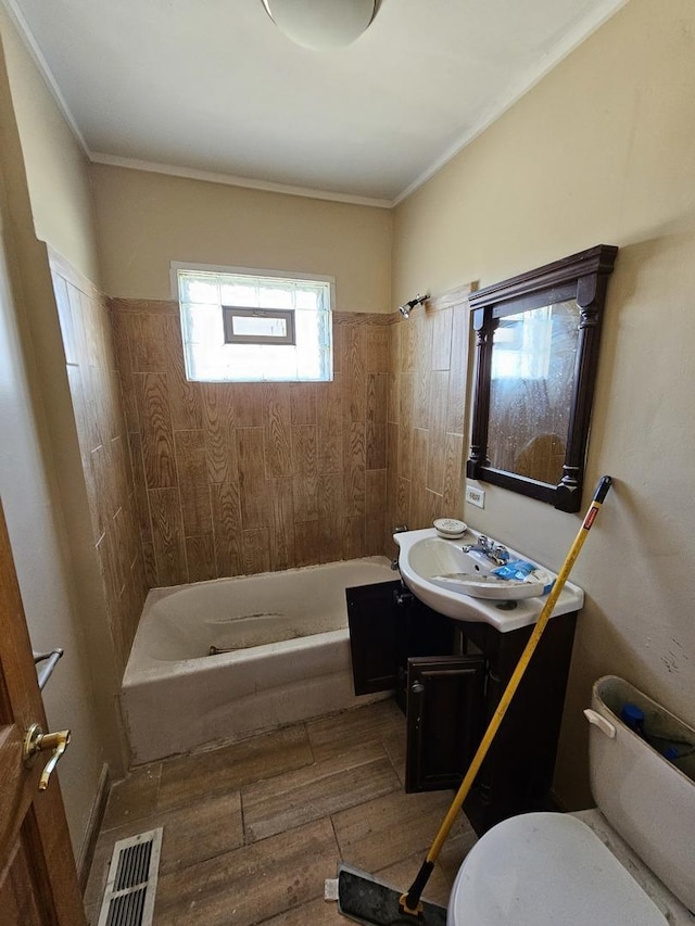 full bathroom with hardwood / wood-style floors, vanity, crown molding, toilet, and shower / bathtub combination