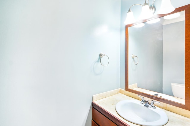 bathroom featuring crown molding, vanity, and toilet