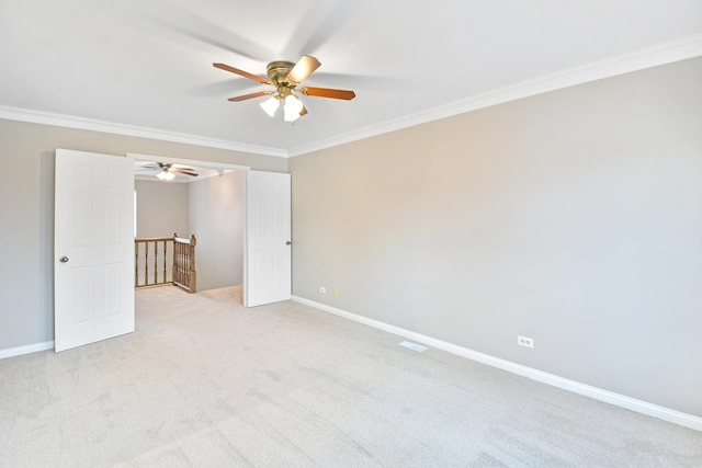 carpeted spare room featuring ceiling fan and ornamental molding