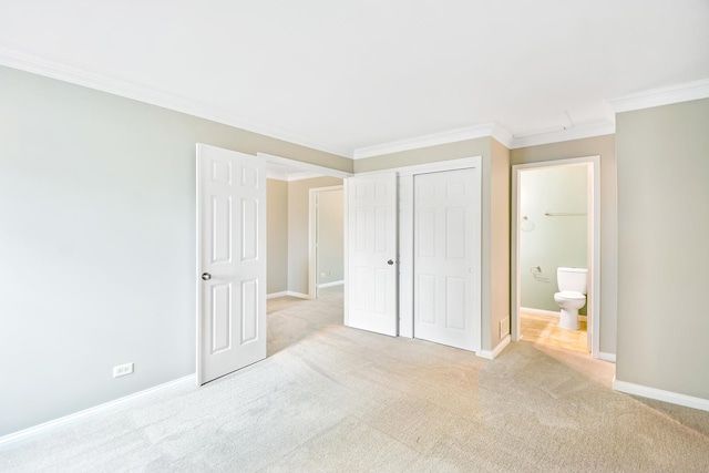 unfurnished bedroom with ensuite bathroom, light colored carpet, crown molding, and a closet