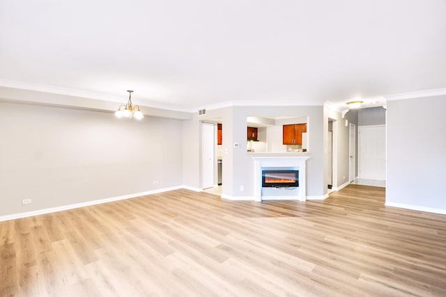 unfurnished living room with light hardwood / wood-style floors, a notable chandelier, and ornamental molding