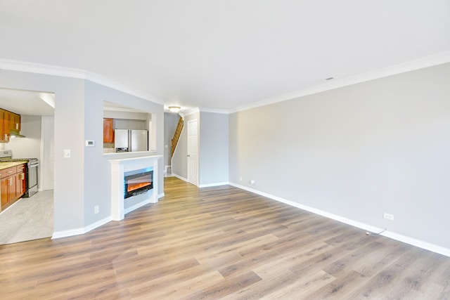 unfurnished living room with crown molding and light hardwood / wood-style flooring