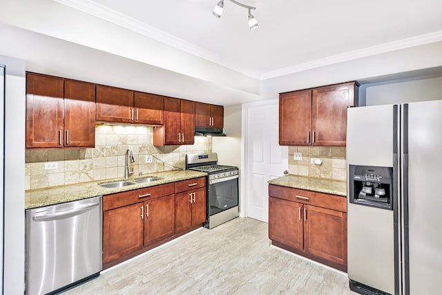 kitchen with light stone countertops, appliances with stainless steel finishes, tasteful backsplash, sink, and light hardwood / wood-style flooring