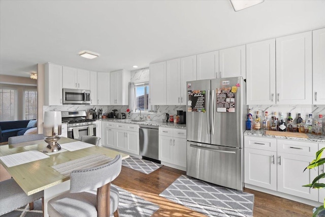 kitchen with appliances with stainless steel finishes, dark hardwood / wood-style floors, and white cabinetry