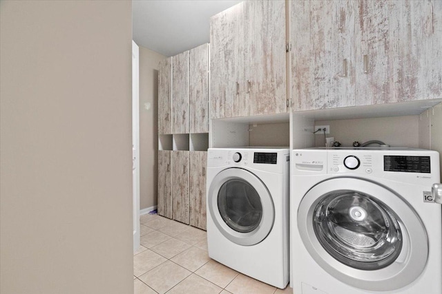 clothes washing area with washer and dryer and light tile patterned floors