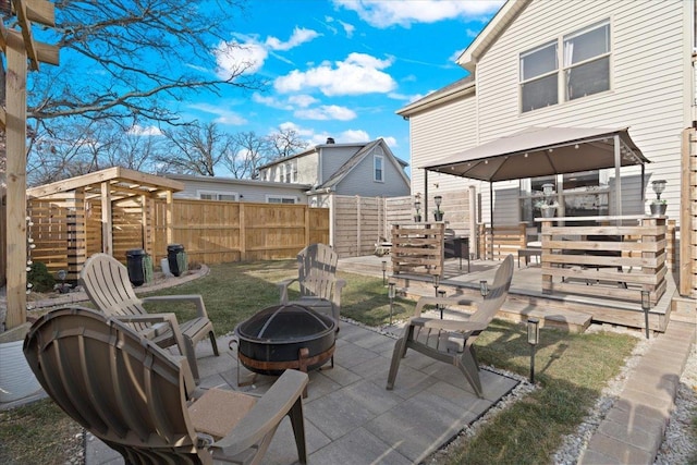 view of patio featuring an outdoor fire pit and a storage shed