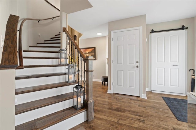 entrance foyer with dark hardwood / wood-style floors and a barn door