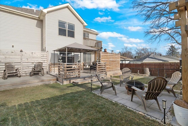 rear view of house featuring a lawn, a patio area, and a fire pit