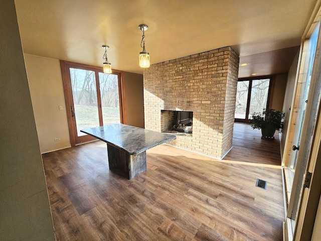 kitchen with a breakfast bar, a healthy amount of sunlight, a fireplace, and pendant lighting