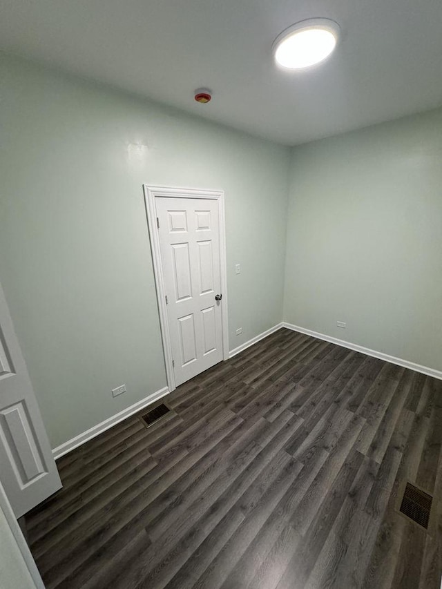 unfurnished room featuring dark wood-type flooring