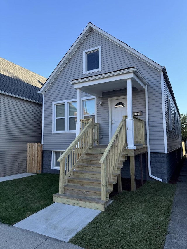 view of front of home with covered porch and a front lawn