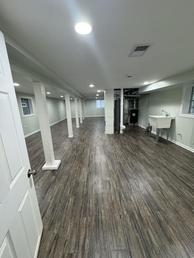 basement featuring sink and dark wood-type flooring