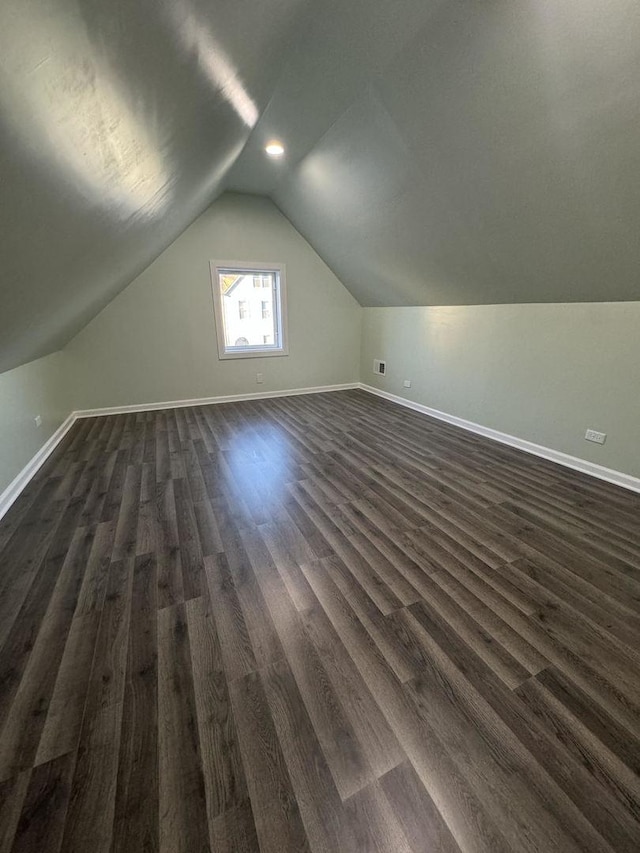 additional living space featuring dark hardwood / wood-style floors and lofted ceiling