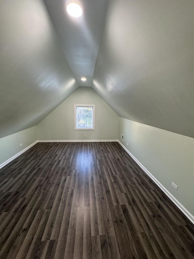 additional living space featuring lofted ceiling and dark wood-type flooring