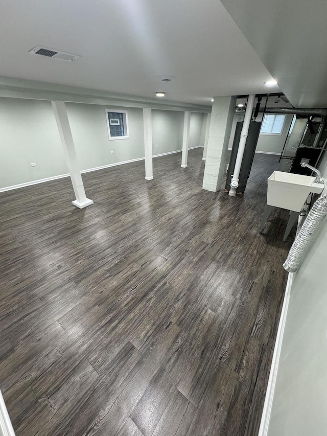 basement featuring dark hardwood / wood-style floors and sink