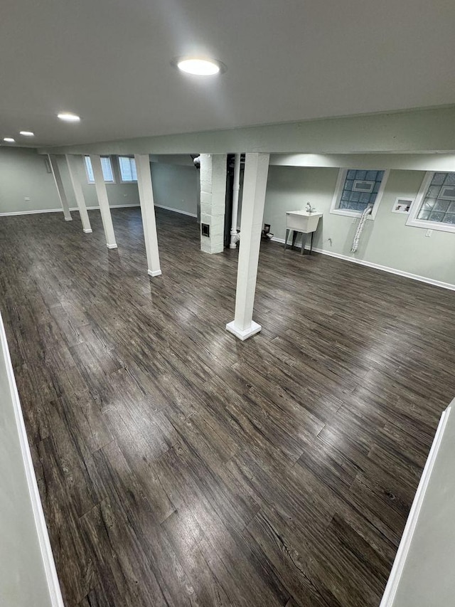 basement with dark hardwood / wood-style floors