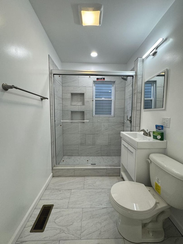 bathroom featuring vanity, toilet, and a shower with door