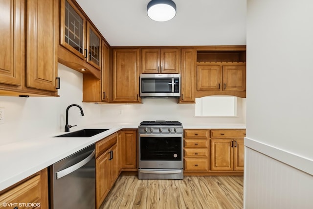 kitchen featuring appliances with stainless steel finishes, light wood-type flooring, and sink