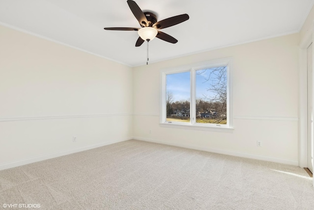 empty room with ceiling fan, light colored carpet, and ornamental molding