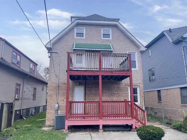 back of house featuring central AC unit and brick siding