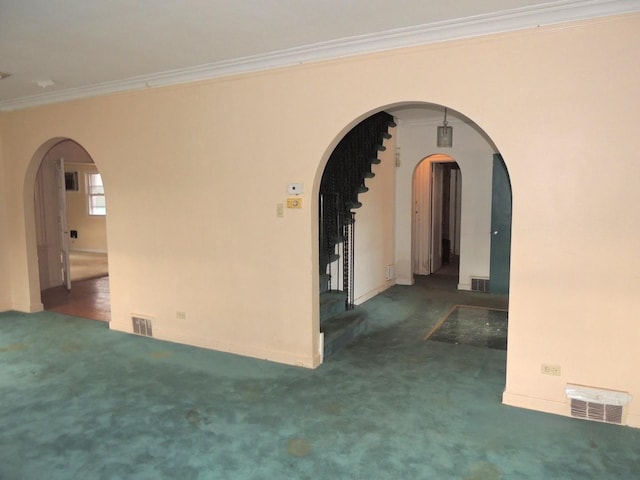 empty room featuring dark colored carpet and ornamental molding