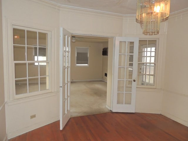 interior space with hardwood / wood-style flooring, an inviting chandelier, crown molding, and french doors