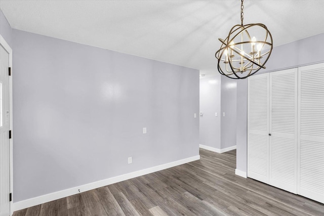 interior space with wood-type flooring, a textured ceiling, and a notable chandelier