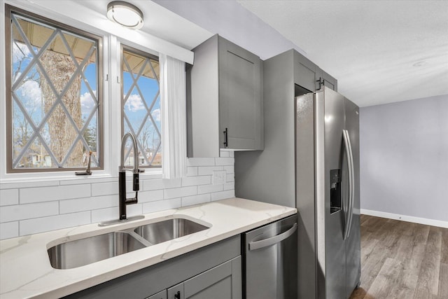 kitchen with gray cabinets, sink, and stainless steel appliances