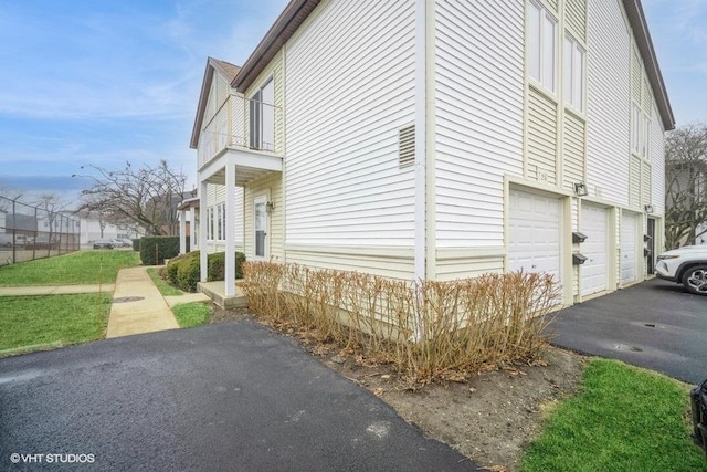 view of side of home with a balcony and a garage