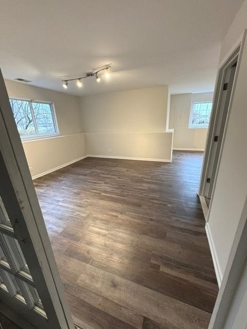 unfurnished room with dark hardwood / wood-style flooring and plenty of natural light