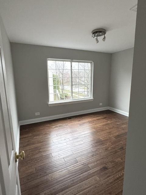 unfurnished room with dark wood-type flooring