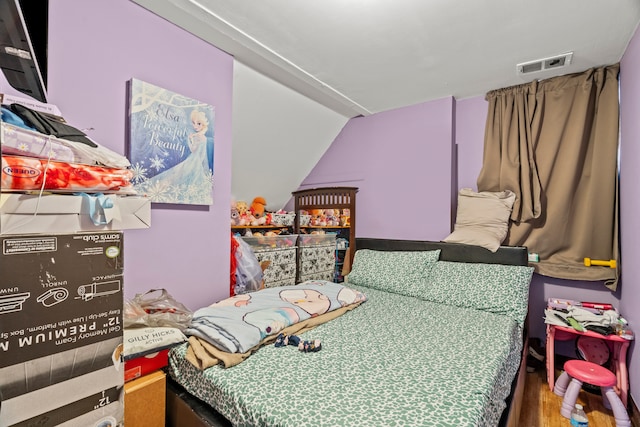 bedroom with hardwood / wood-style flooring and vaulted ceiling